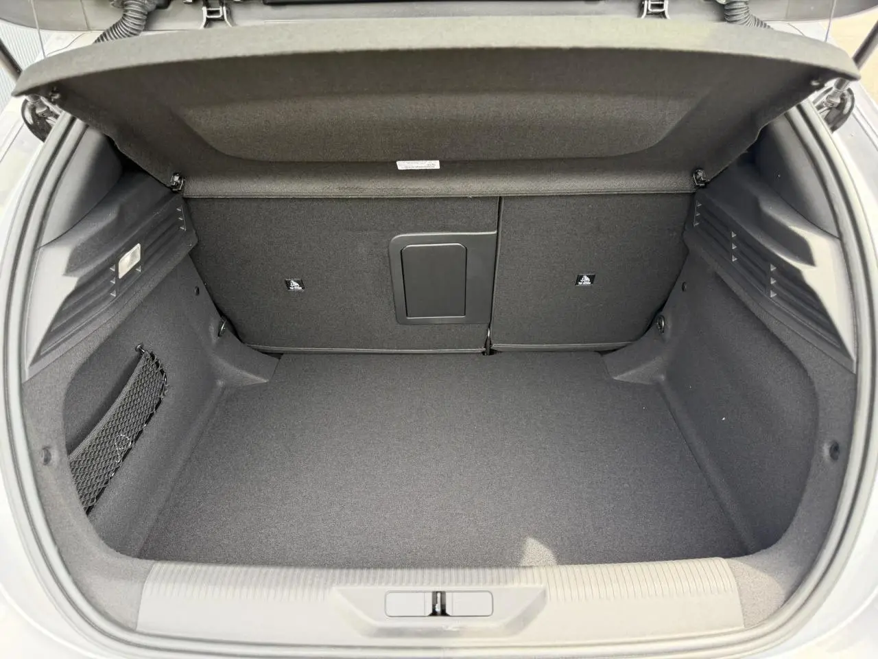 Coffre ouvert vu de l'arrière d'une Peugeot 308 gris Artense, montrant l'espace de chargement intérieur.