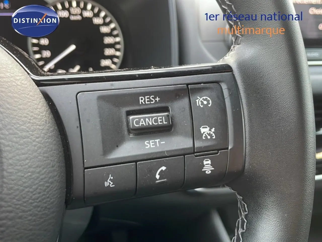 Gros plan sur les commandes au volant du Nissan Qashqai 2023, finition Business Edition, volant cuir noir.