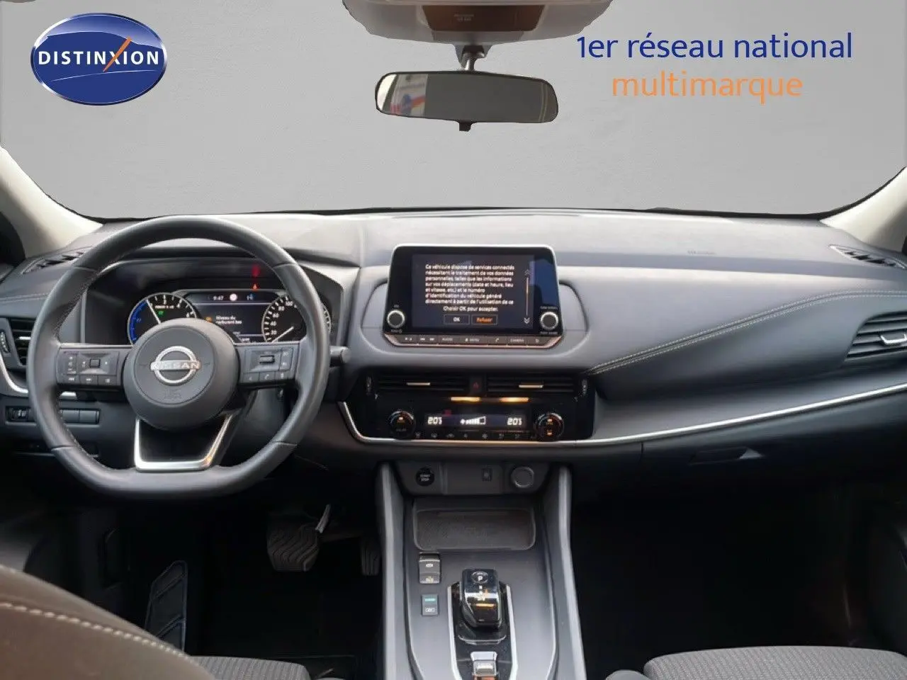 Vue intérieure frontale du Nissan Qashqai 2023 noir métal, tableau de bord moderne avec écran tactile central et volant multifonction.