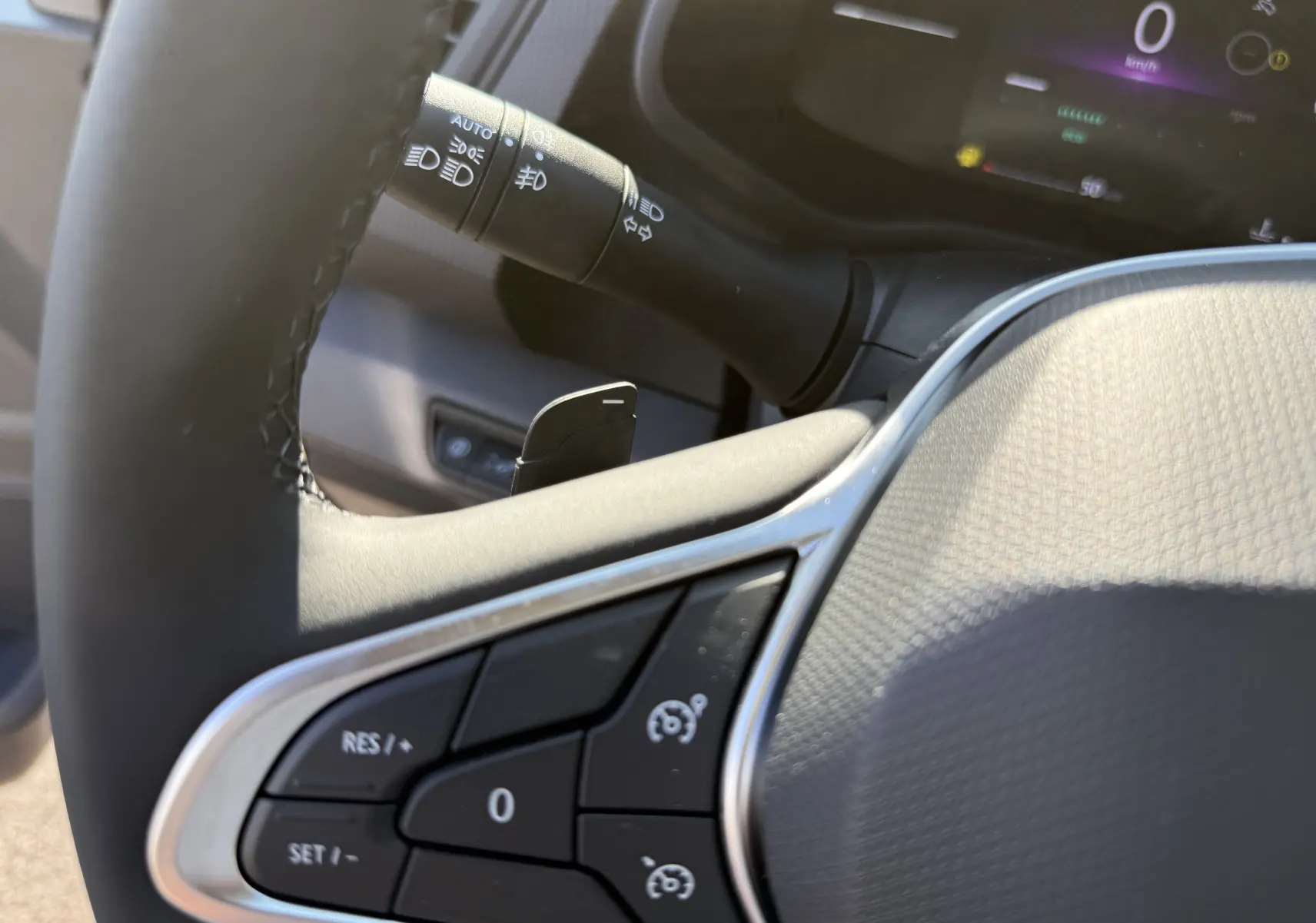 Détail du volant noir du Renault Trafic cabine approfondie 2025, avec commandes de régulateur de vitesse et levier de clignotant.