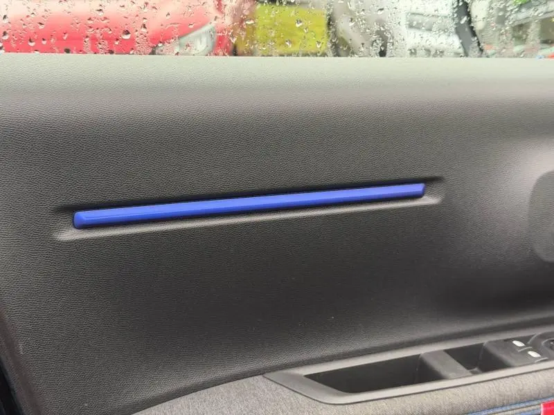 Détail intérieur côté gauche de la porte d’une Citroën C3 2025 noir Perla Nera avec insert décoratif bleu.