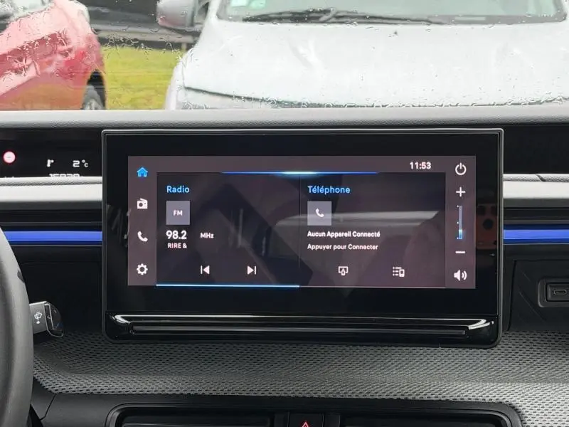 Écran tactile central du tableau de bord de la Citroën C3 2025, affichant radio et téléphone, intérieur moderne noir.
