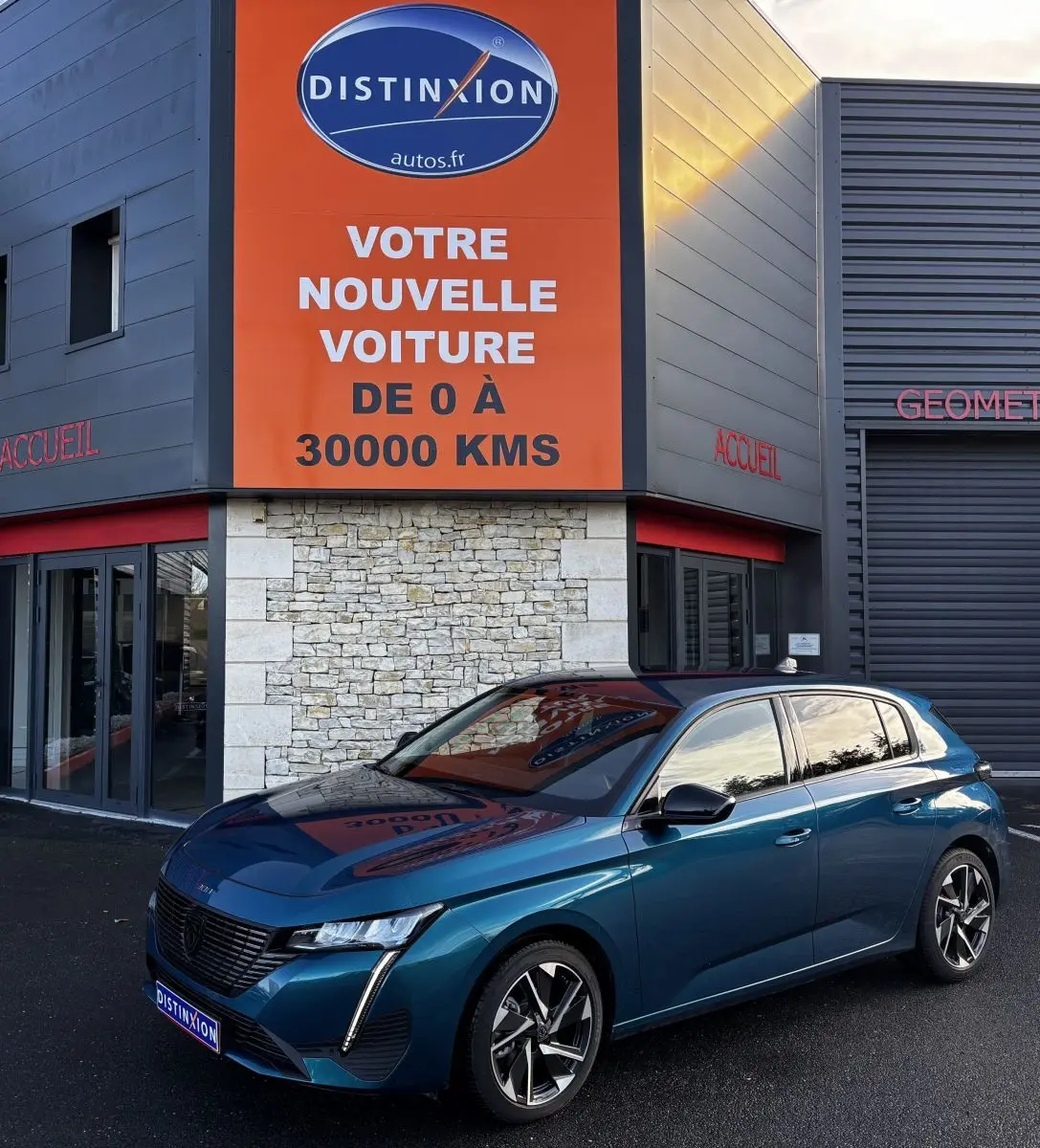 Peugeot 308 Hybrid 136 e-DCS6 Allure bleu vue 3/4 avant droit, avec feux LED et jantes alliage distinctives.