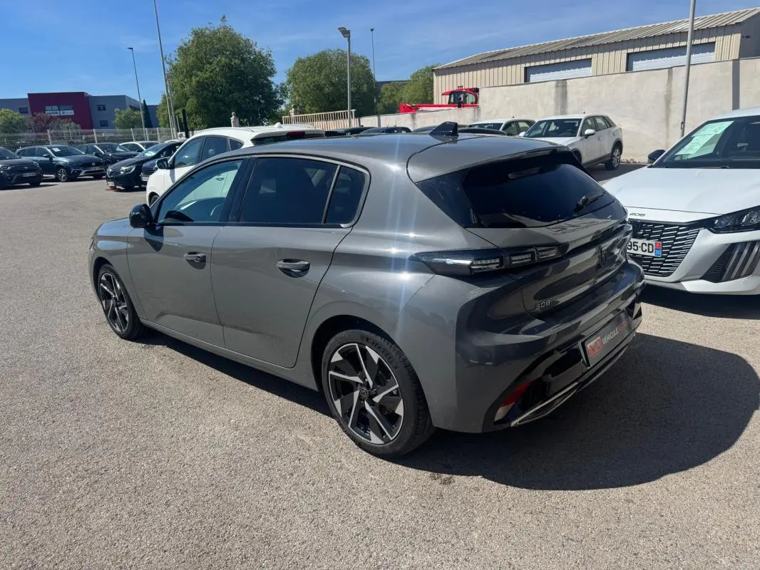 Peugeot 308 Hybrid gris en 3/4 arrière droit, avec jantes alliage 17 pouces et vitres teintées.