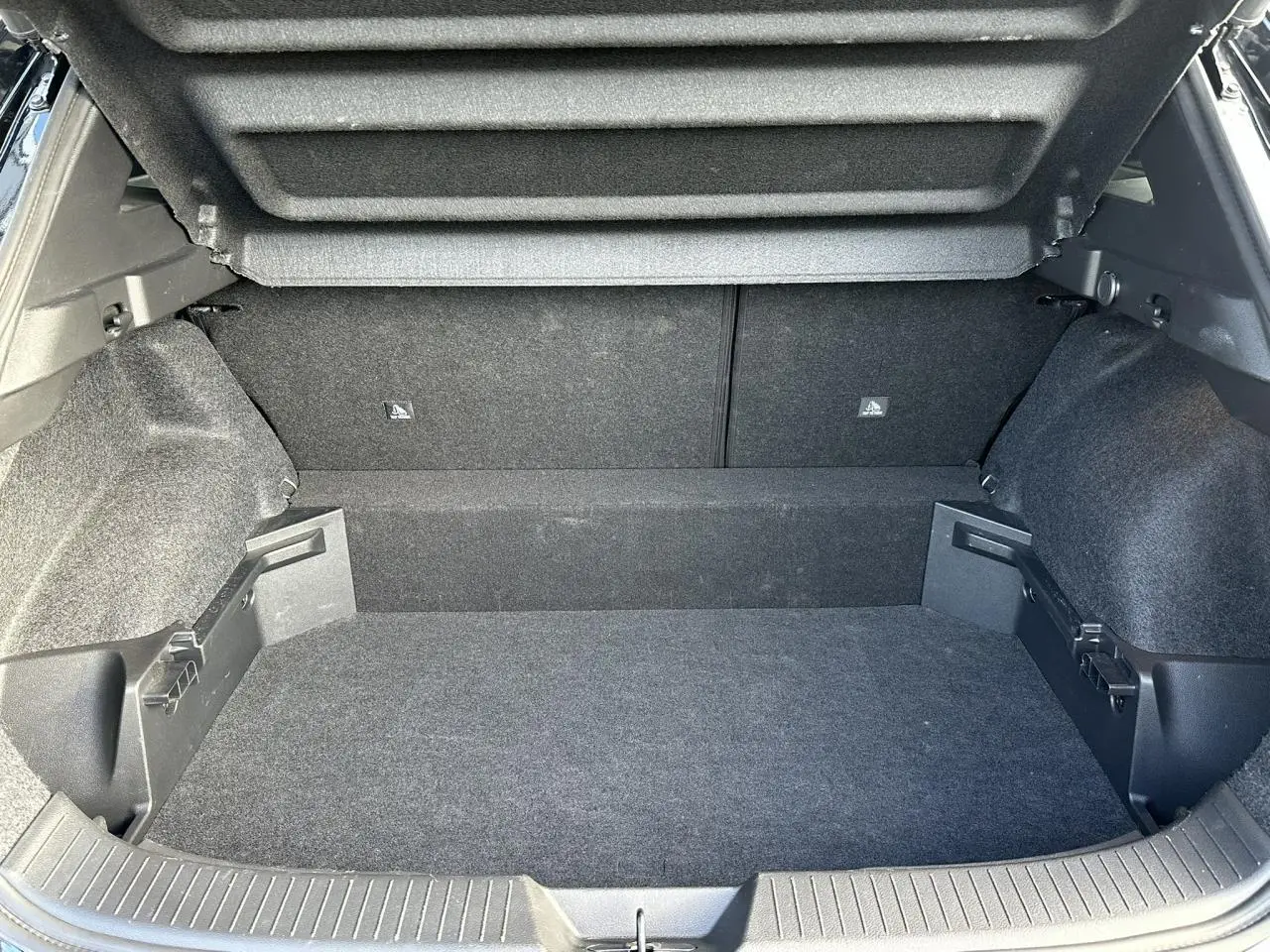 Coffre ouvert du Nissan Qashqai 2025 noir nacré, vue intérieure montrant le plancher modulable et le hayon électrique.