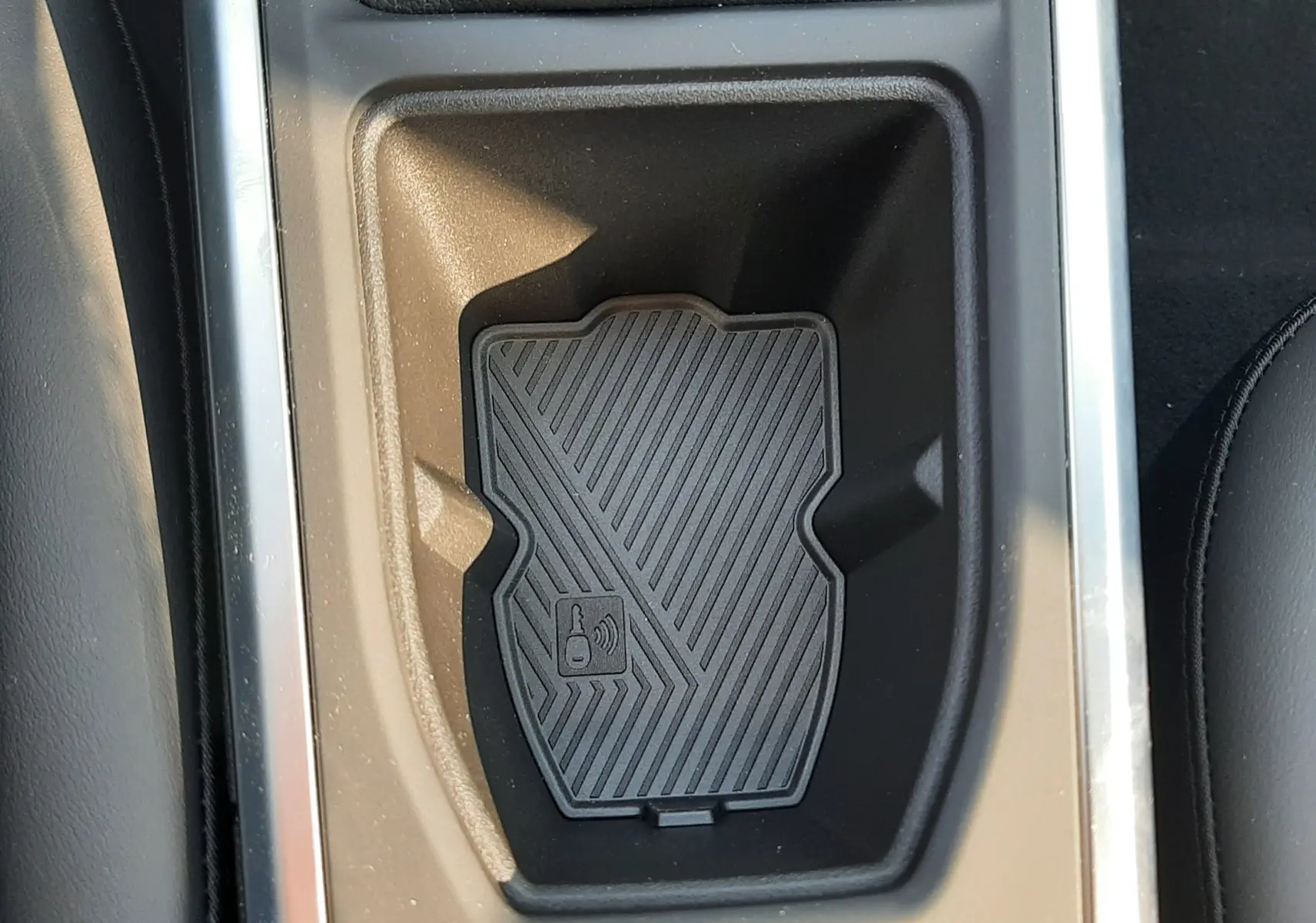 Gros plan sur le compartiment de recharge sans fil dans la console centrale de la Renault Clio VI TCe 115ch Techno.