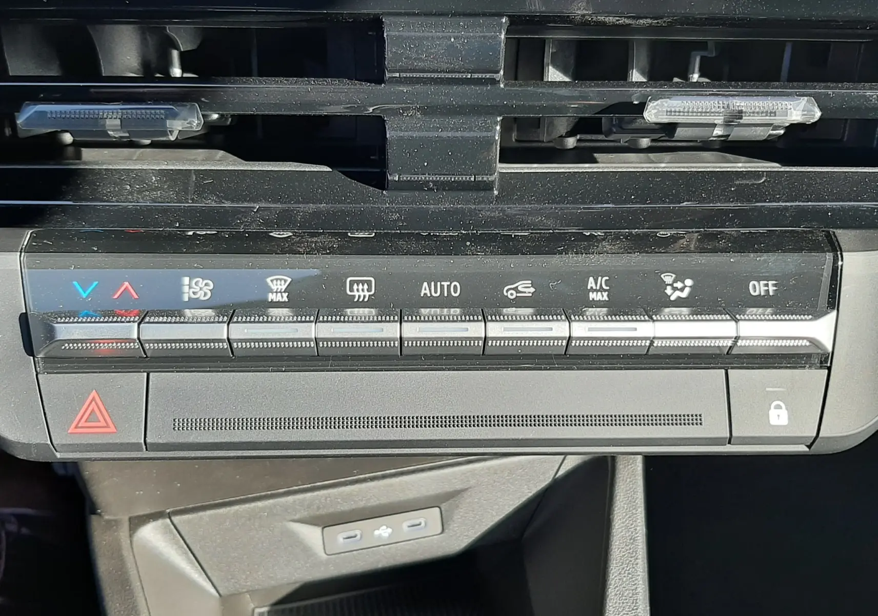 Gros plan sur la console de climatisation noire de la Renault Clio VI TCe 115ch Techno, avec commandes tactiles et voyants lumineux.