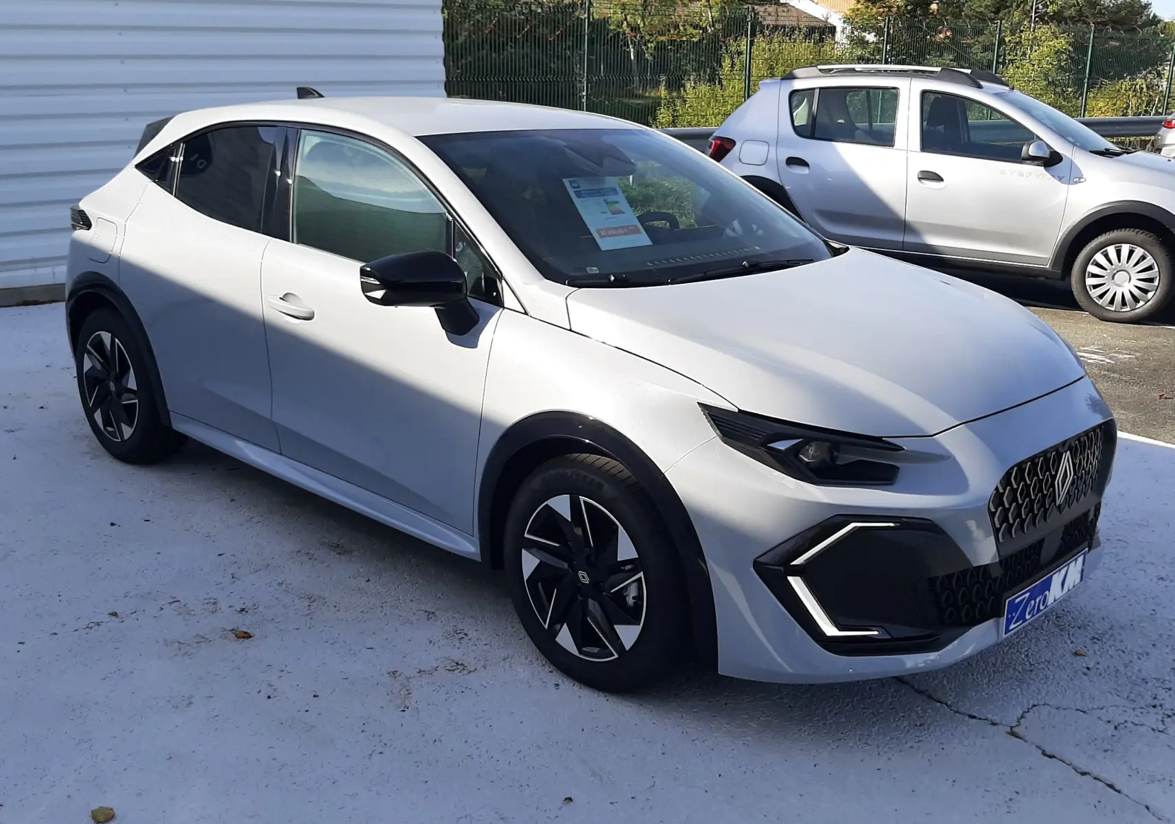 Renault Clio VI TCE 115ch Techno gris Rafale vue 3/4 avant droit, avec calandre noire et jantes distinctives.