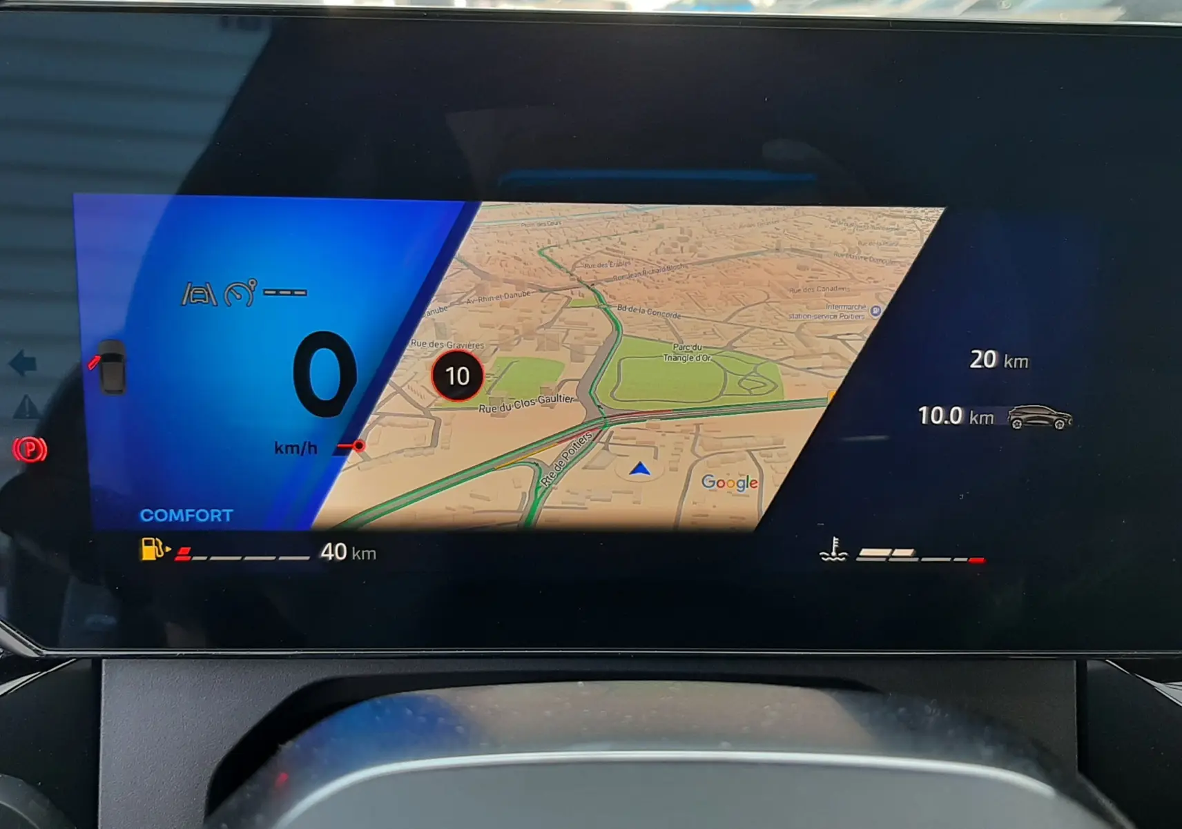 Affichage numérique du tableau de bord de la Renault Clio VI gris Rafale, montrant la navigation et les indicateurs de conduite.