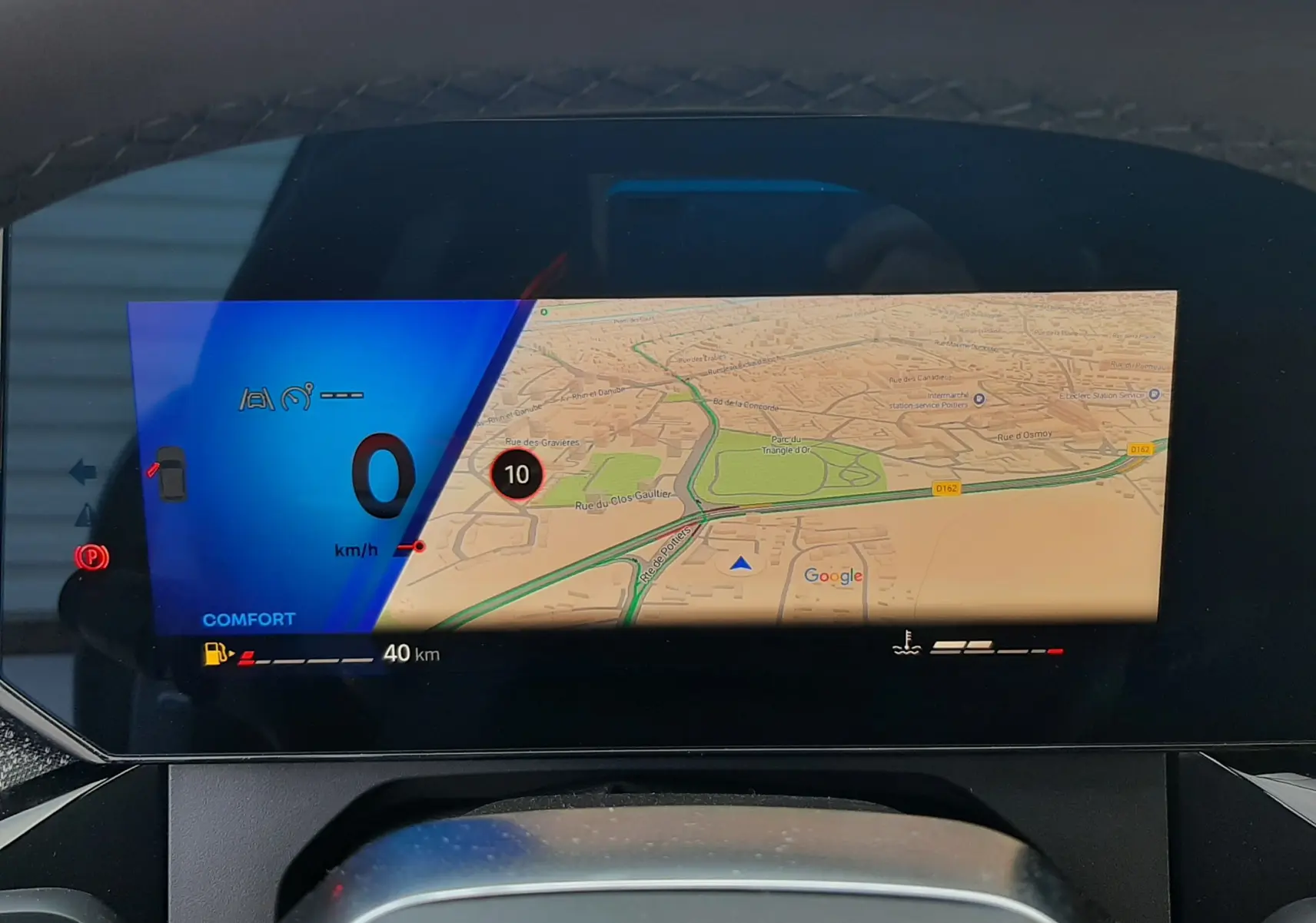 Vue intérieure du tableau de bord numérique de la Renault Clio VI TCe 115ch Techno, affichant la navigation et l'indicateur de vitesse.