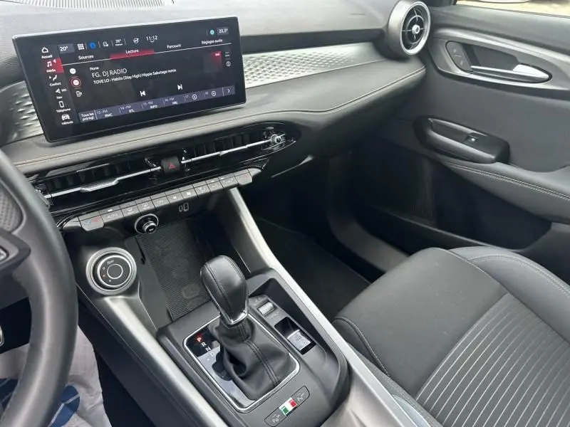 Intérieur de l'Alfa Romeo Tonale 2024, vue côté passager, tableau de bord moderne et levier de boîte auto noir.