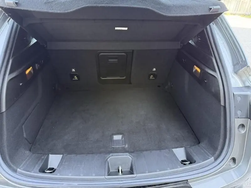 Coffre ouvert vu de l'arrière d'un Alfa Romeo Tonale gris foncé métal, montrant un espace de chargement propre et spacieux.