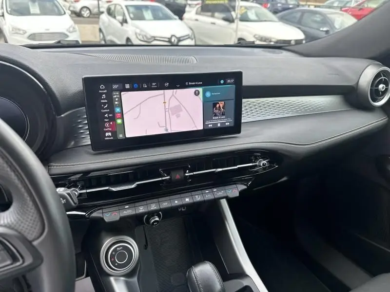 Intérieur de l'Alfa Romeo Tonale 2024 montrant le tableau de bord moderne avec écran tactile et finitions noires élégantes.