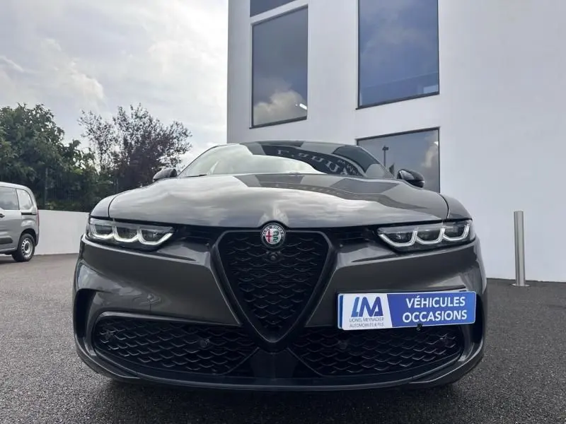 Vue frontale de l'Alfa Romeo Tonale 1.5 Hybrid gris foncé métal avec calandre caractéristique et phares LED distinctifs.
