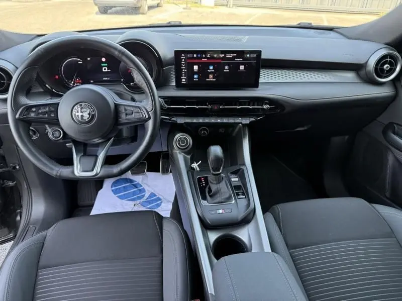 Intérieur de l'Alfa Romeo Tonale 1.5 Hybrid 130ch Sprint vu de face, avec tableau de bord numérique et écran tactile central.