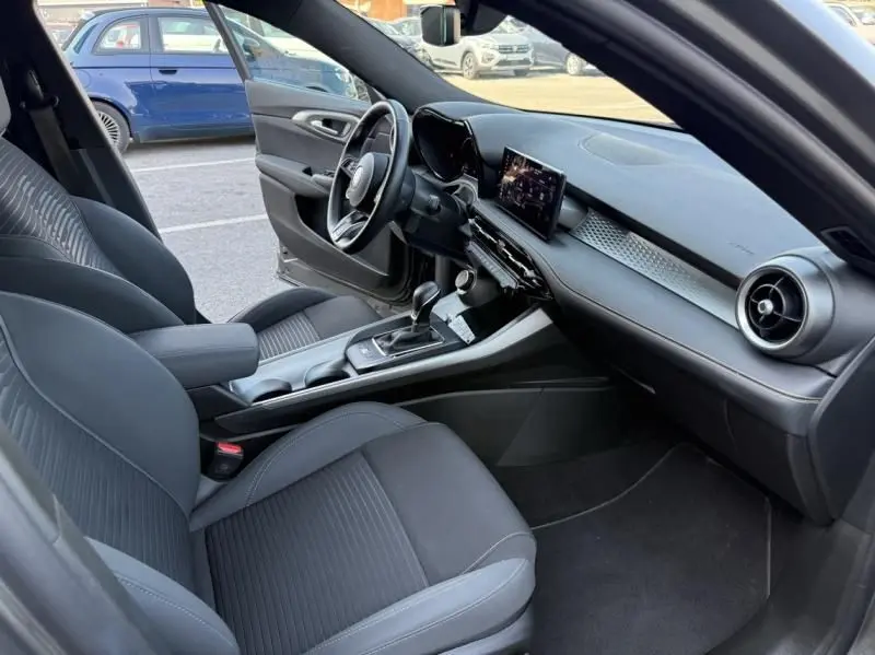 Intérieur de l'Alfa Romeo Tonale 1.5 Hybrid 130ch Sprint 2024, vue côté conducteur, sièges noirs et tableau de bord moderne.