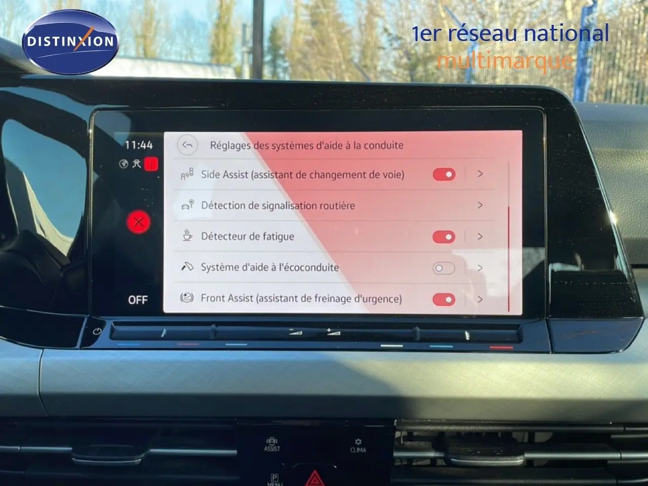 Écran central tactile affichant les réglages d’aide à la conduite dans l’habitacle d’une Volkswagen Golf VIII rouge.