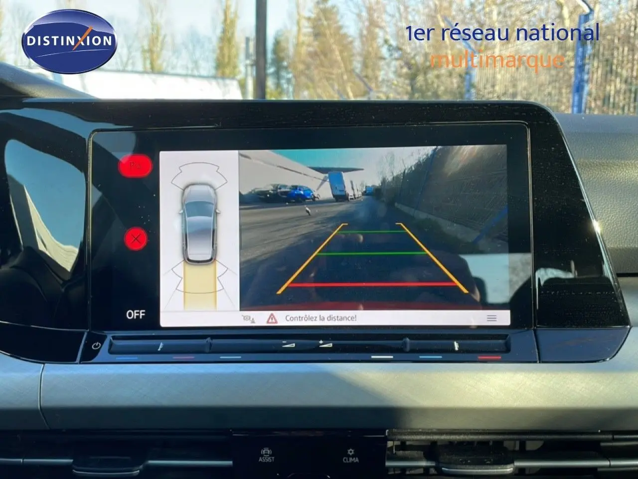 Écran central de la Volkswagen Golf VIII rouge, affichant la caméra de recul avec guidage de trajectoire.