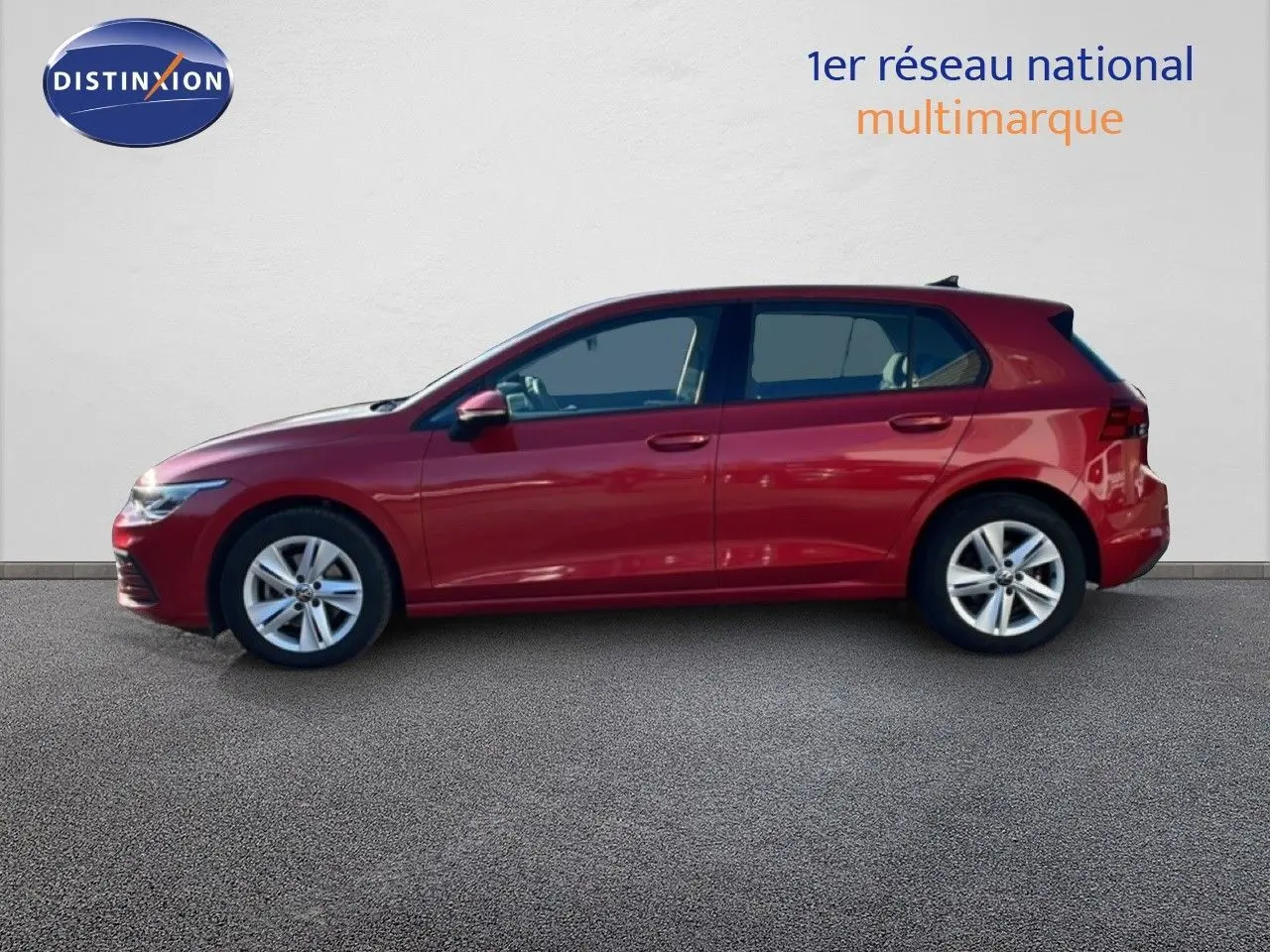 Vue latérale droite d'une Volkswagen Golf VIII rouge Roi Metal 2023, avec jantes alliage et lignes épurées.