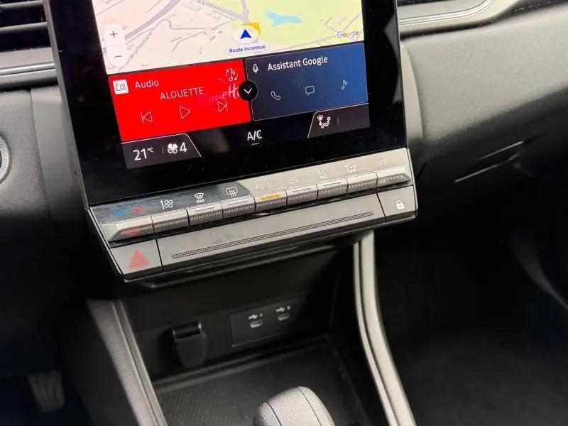 Détail de la console centrale du Renault Captur 2025 avec écran tactile et commandes climatisation, intérieur noir.