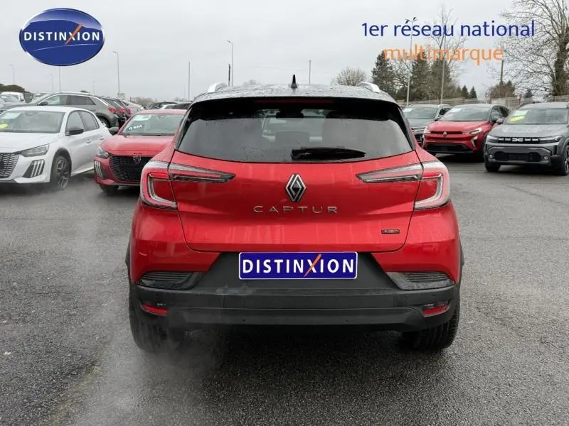 Vue arrière d'un Renault Captur 1.6 E-Tech full hybrid rouge flamme, avec logo et feux LED distinctifs visibles.