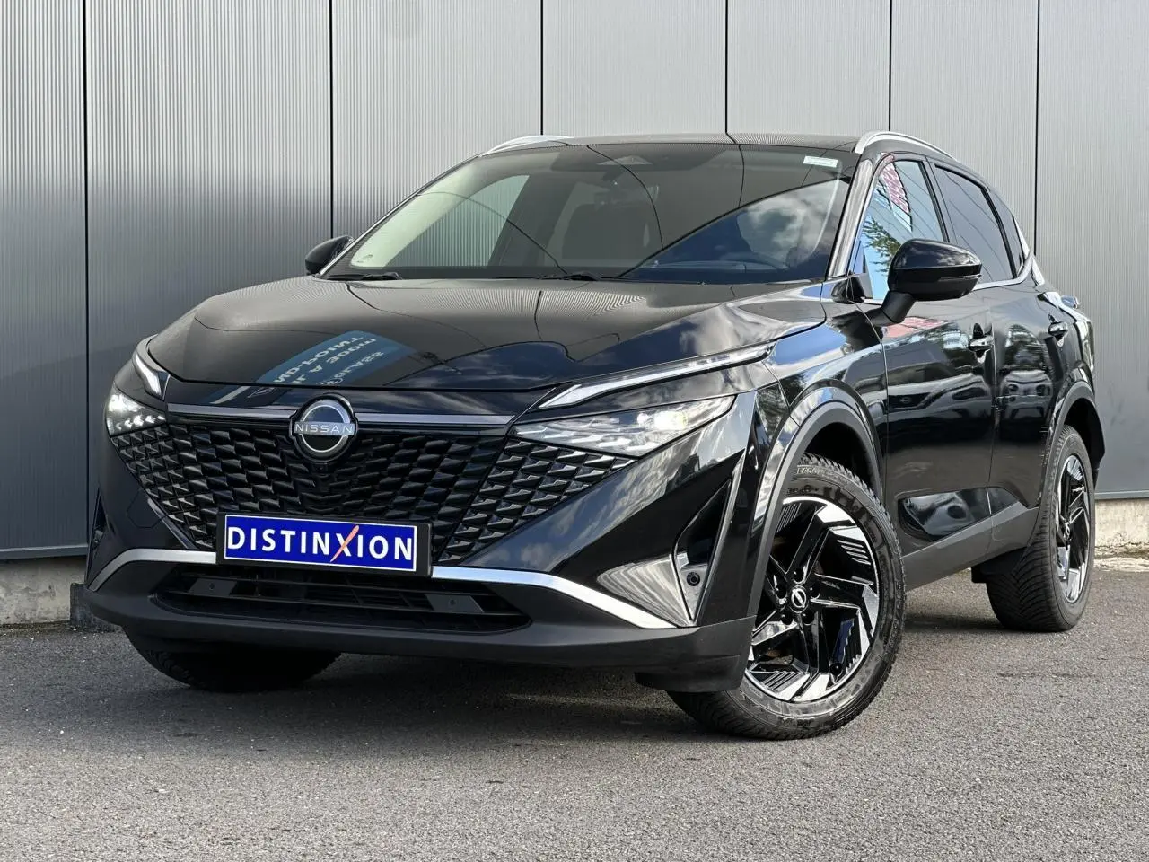Nissan Qashqai noir nacré en 3/4 avant droit, avec calandre distinctive et jantes alliage noires.