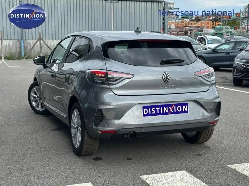 Vue 3/4 arrière droite d'une Renault Clio gris Rafale 2025 avec feux arrière LED et becquet arrière.
