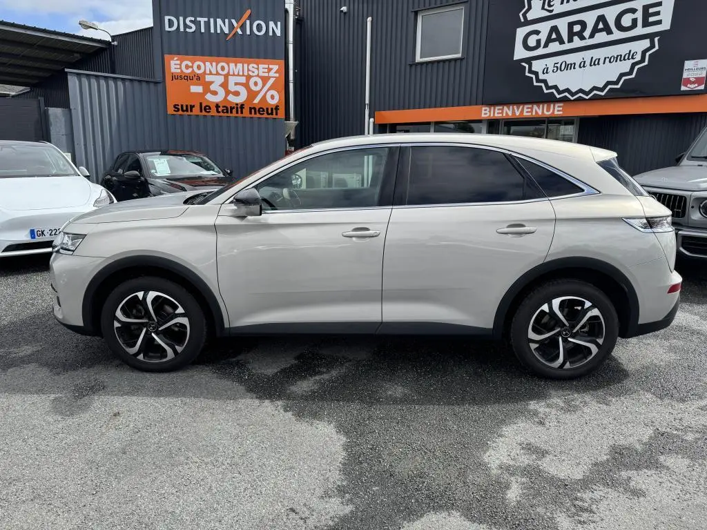 Vue latérale droite d'un DS7 Crossback gris métallisé 2022 avec jantes alliage noires et vitres teintées.