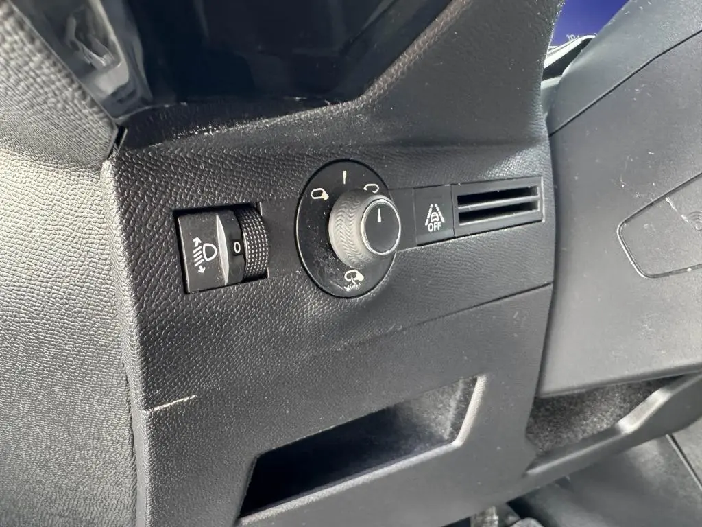 Gros plan sur les commandes d'éclairage et d'aide à la conduite côté gauche du tableau de bord noir du DS7 Crossback gris.