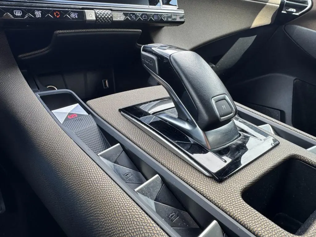 Le levier de vitesse automatique noir et cuir du DS7 Crossback 2022, entouré de console en tissu bronze et commandes électriques.