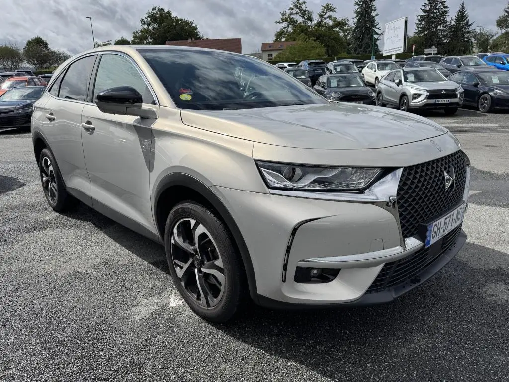 DS7 Crossback gris métallisé vu en 3/4 avant droit, avec calandre DS Wings chromée et jantes alliage noires.