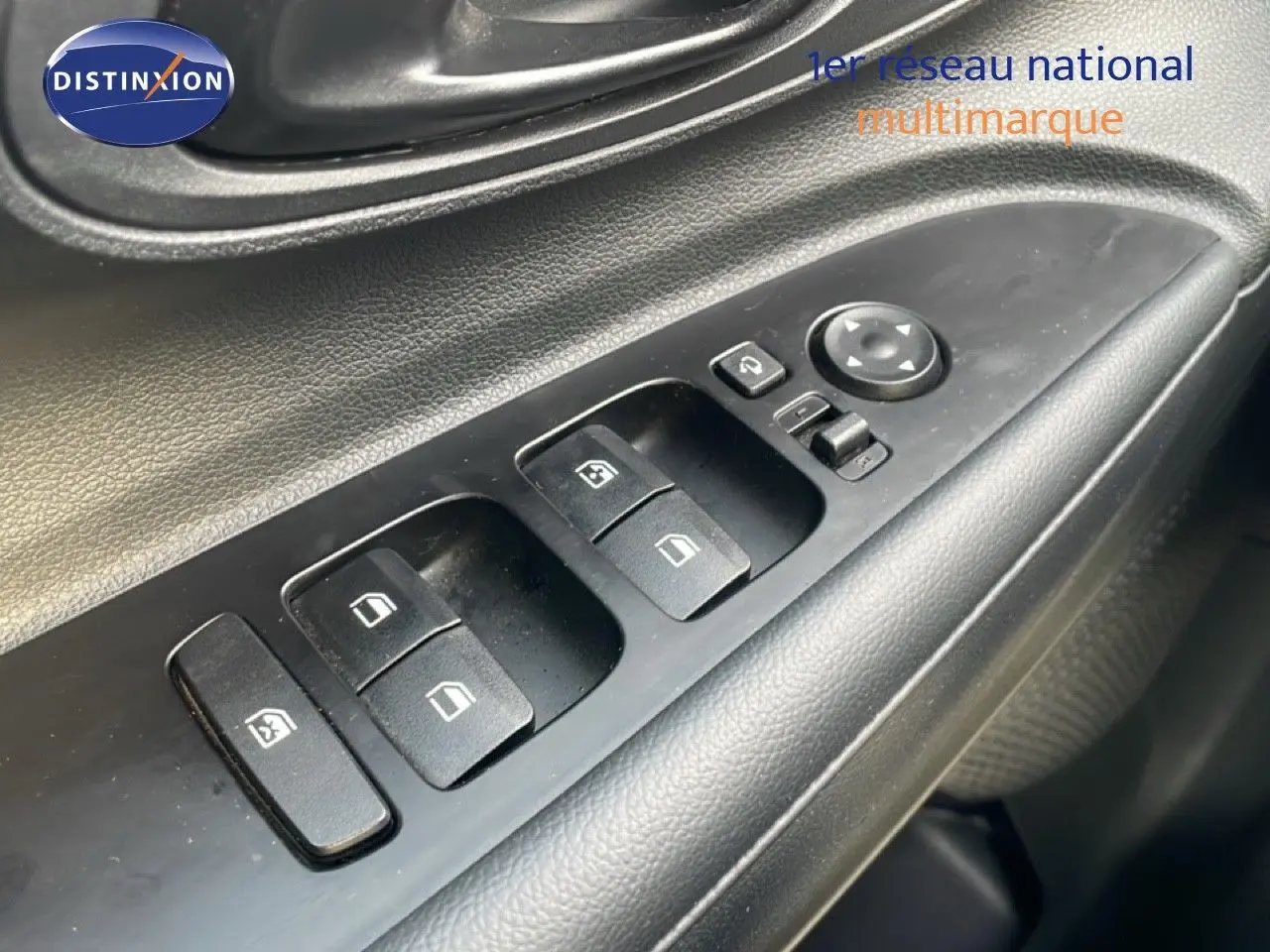 Gros plan sur les commandes des vitres électriques côté conducteur d'une Hyundai i20 2025, intérieur noir.