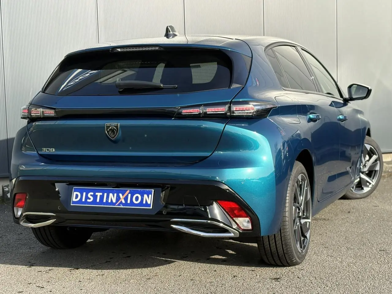 Vue 3/4 arrière droite d'une Peugeot 308 Hybrid 2025 Bleu Obsession avec feux arrière LED et jantes alliage 17 pouces.