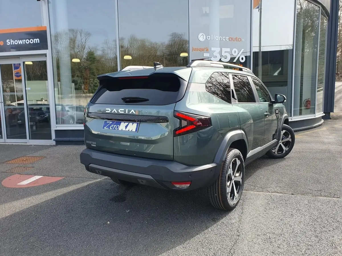 Vue 3/4 arrière droite du Dacia Bigster vert cèdre avec jantes alliage 18” et toit panoramique visible.