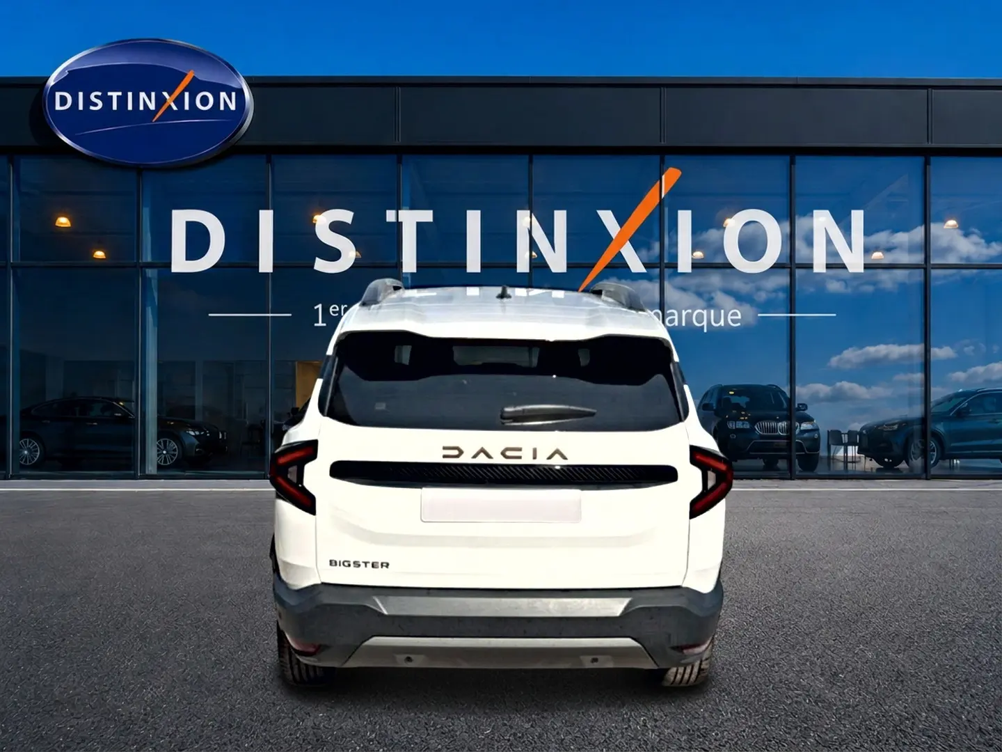 Vue arrière d'un Dacia Bigster blanc stationné devant une vitrine avec logo Distinxion en arrière-plan.