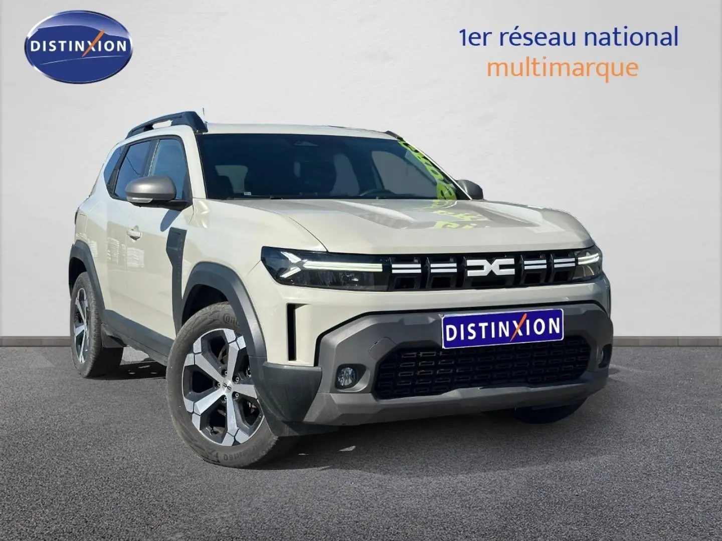 SUV Dacia Duster 2025 Sandstone en 3/4 avant, avec calandre noire distinctive et jantes alu bicolores.