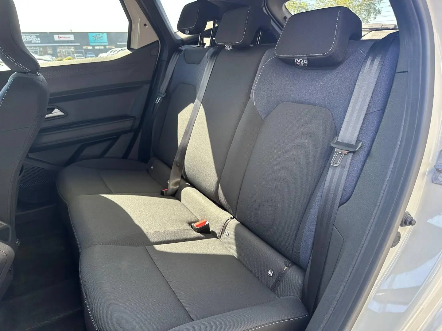 Vue latérale droite de la banquette arrière noire et tissu denim du Dacia Duster 2025, intérieur spacieux et lumineux.