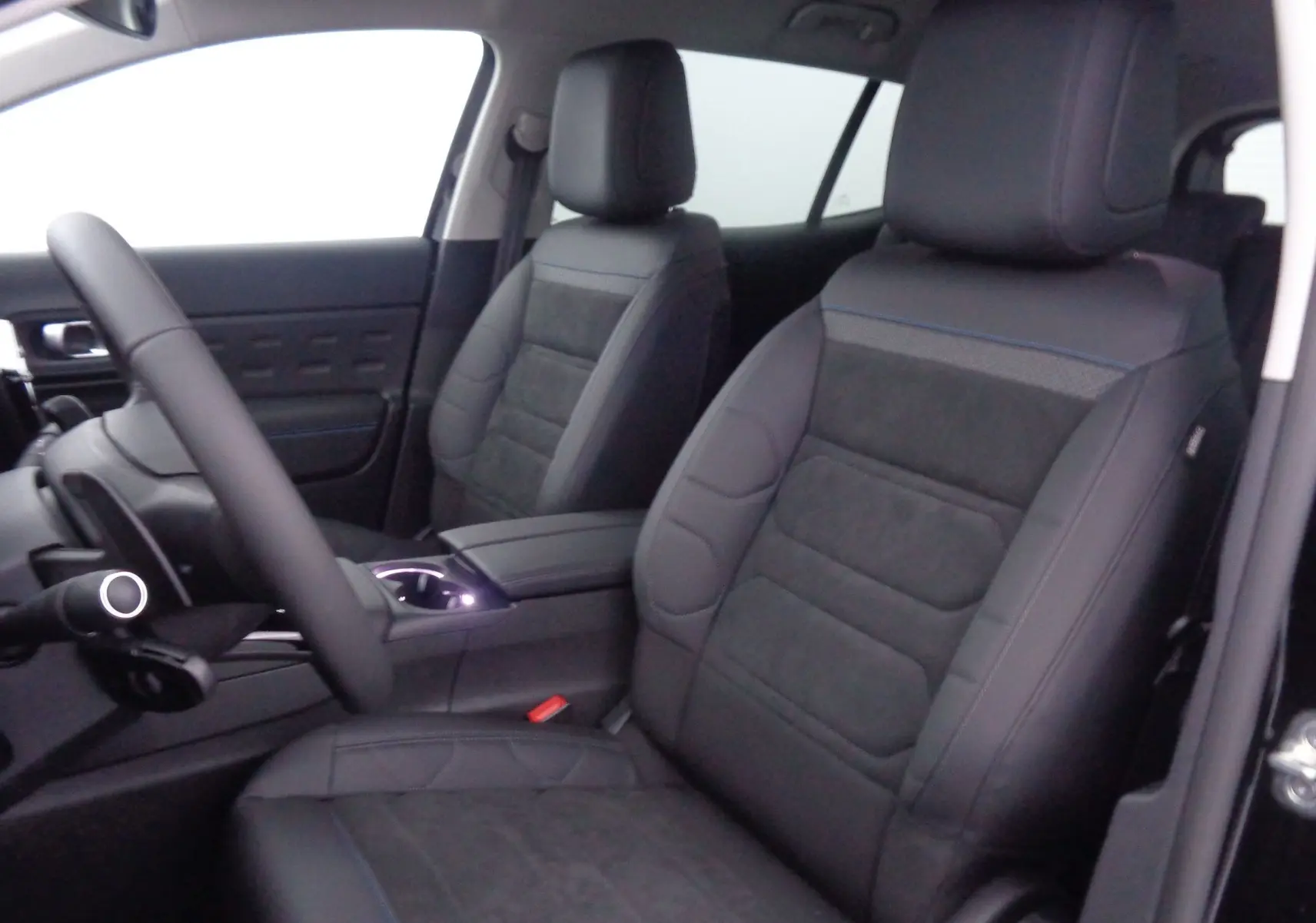 Intérieur du Citroën C5 Aircross 2022 en cuir noir, vue sur les sièges avant et le volant côté gauche.