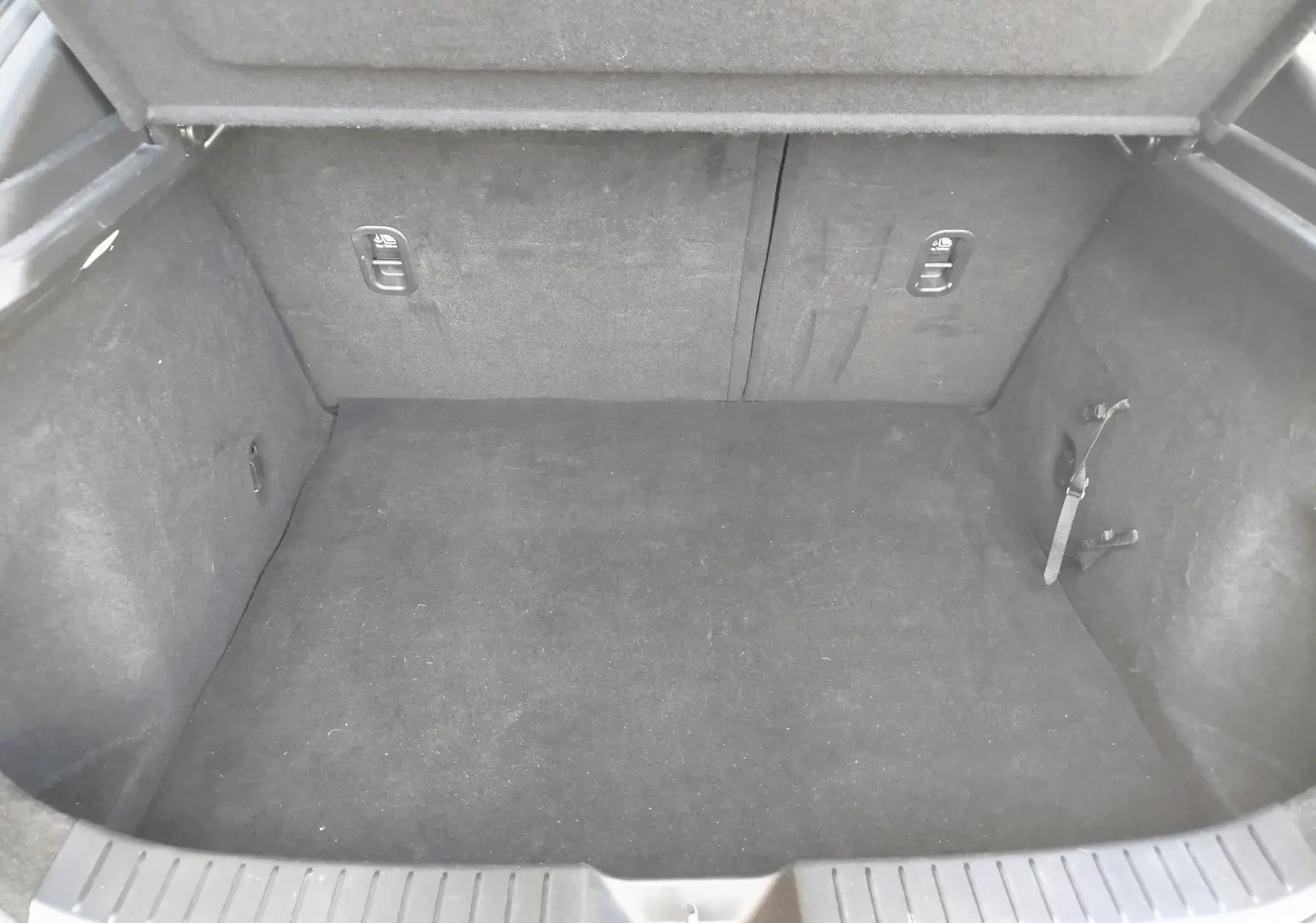 Coffre vide vu de face du Mazda CX-30 noir 2020, avec revêtement intérieur sombre et sangles latérales visibles.