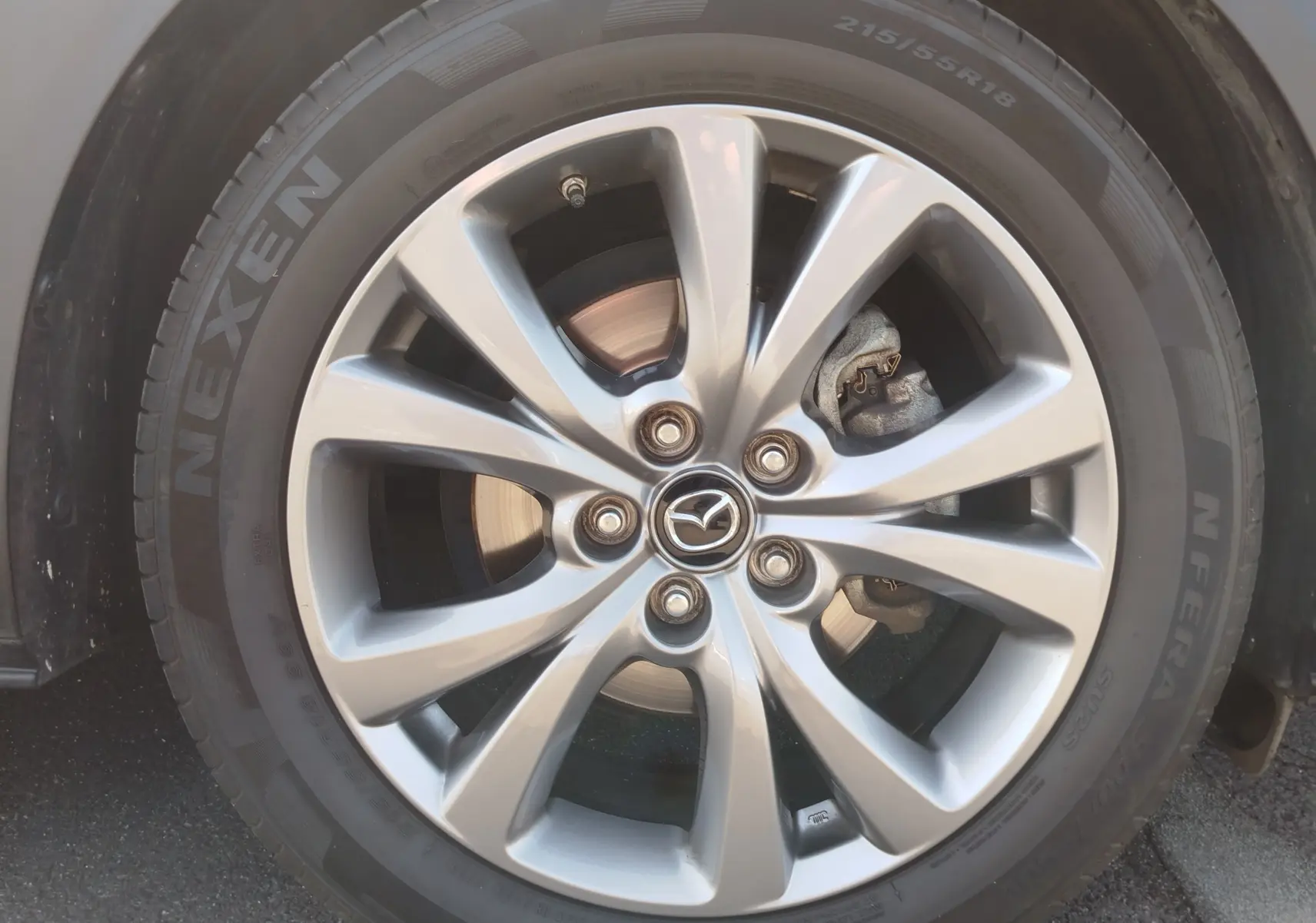 Gros plan sur la jante alliage argentée et le pneu Nexen du Mazda CX-30 noir, modèle 2020.