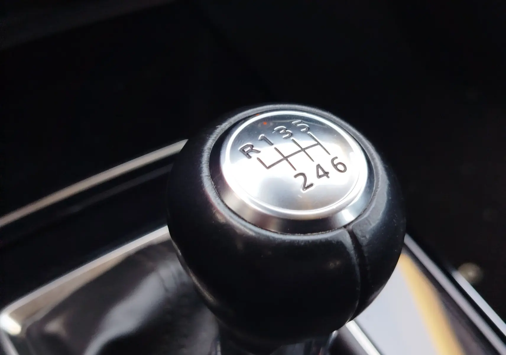 Gros plan sur le pommeau de la boîte manuelle du Mazda CX-30 noir, affichant les six vitesses et la marche arrière.