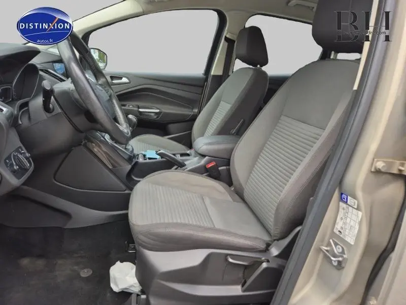 Vue intérieure côté conducteur du Ford C-MAX 2018 avec sièges tissu gris et accoudoir central noir.