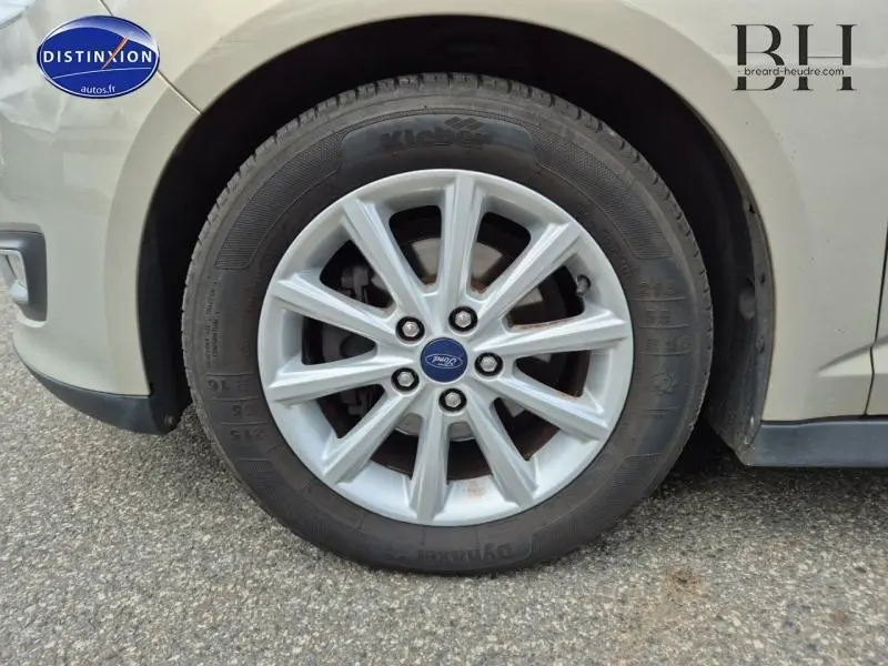 Gros plan sur la roue avant gauche d'une Ford C-MAX 1.0 EcoBoost 2018 couleur Fashion Brun Caribou avec jante alu multibranches.