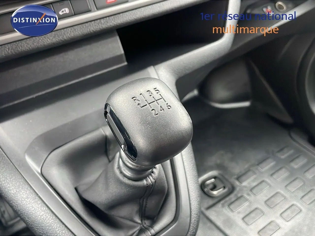 Gros plan sur le levier de vitesses manuel noir du Peugeot Expert Fourgon blanc, montrant les six rapports et la marche arrière.