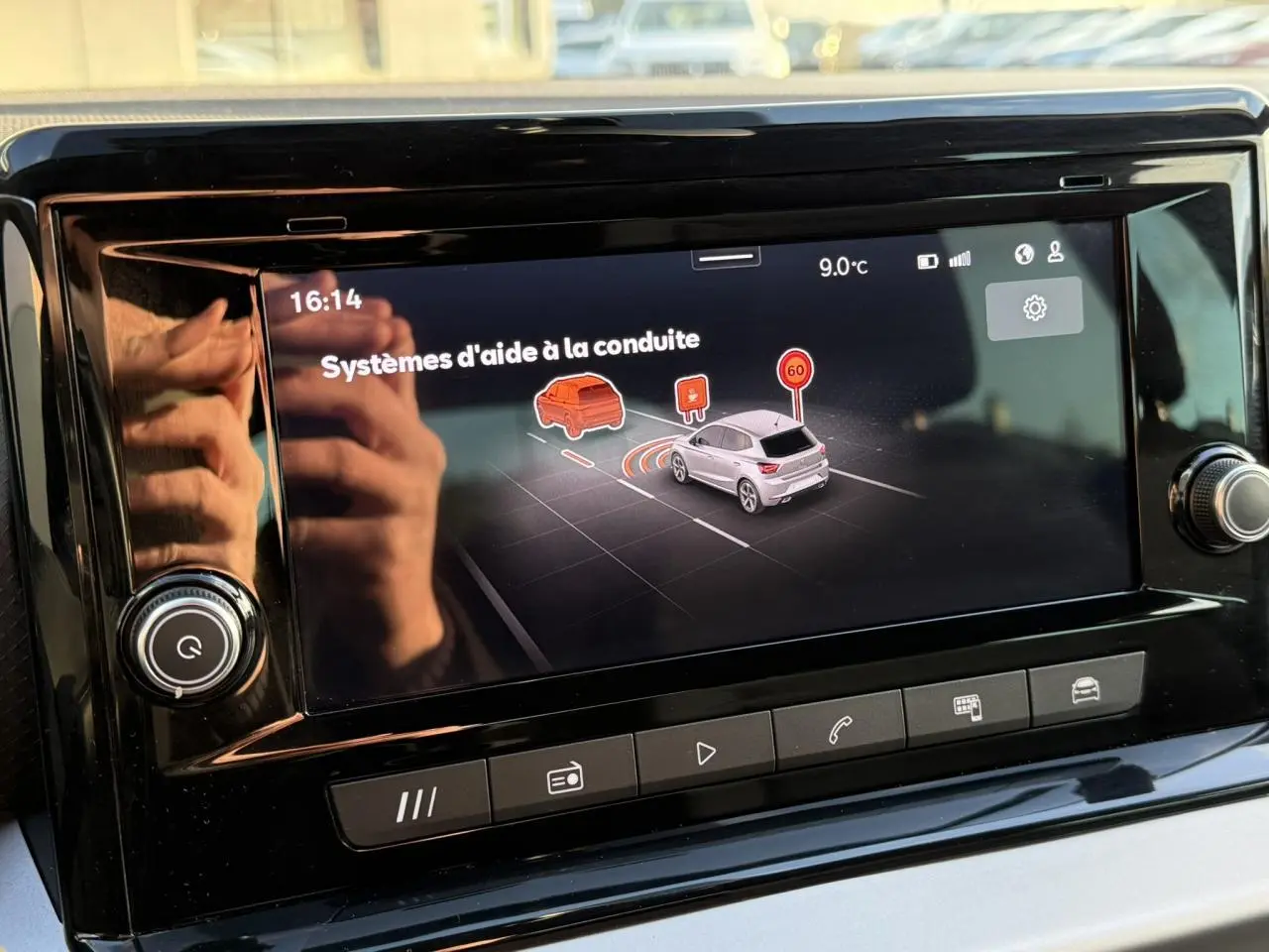 Écran tactile central du tableau de bord de la SEAT Ibiza bleu Fjord affichant les aides à la conduite.