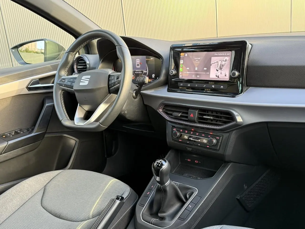 Vue intérieure côté conducteur de la SEAT Ibiza TSI 115 Xcellence 2025, avec tableau de bord moderne et volant cuir multifonction.