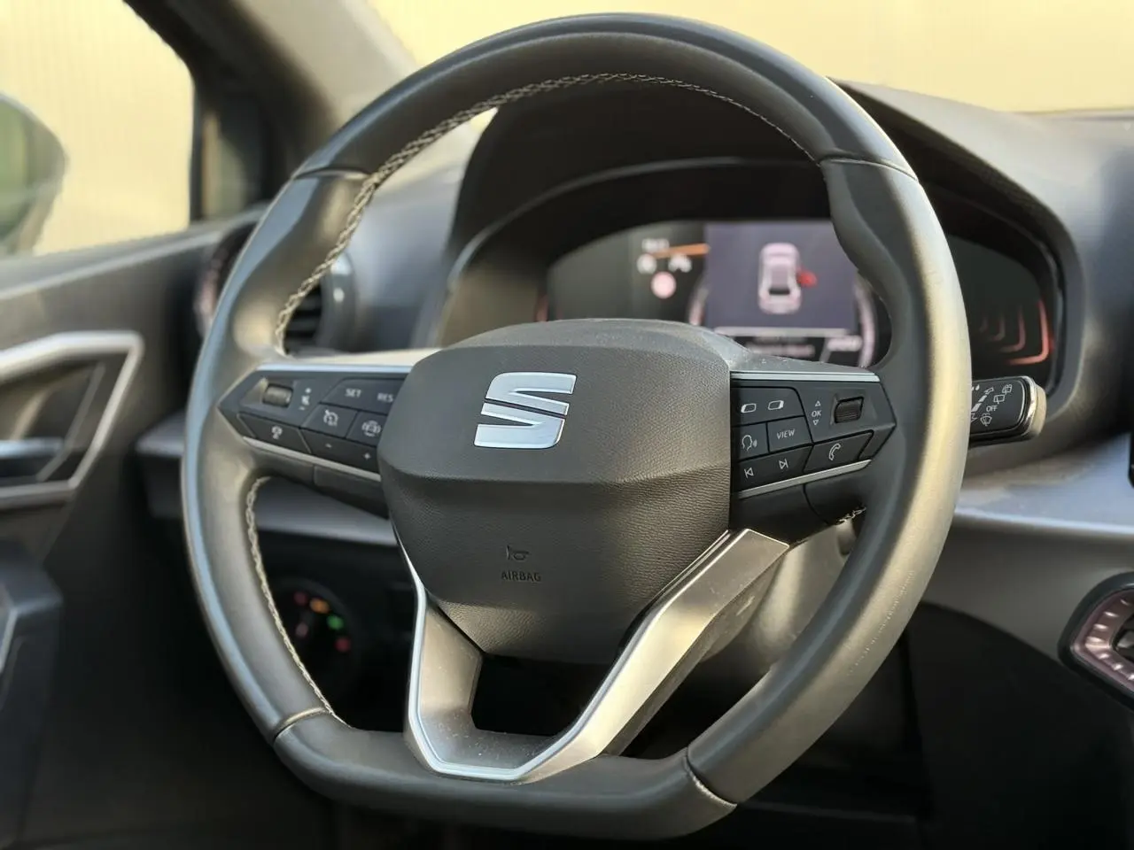 Volant sport cuir multifonction de la SEAT Ibiza TSI 115 Xcellence 2025, vue rapprochée de face sur intérieur noir.