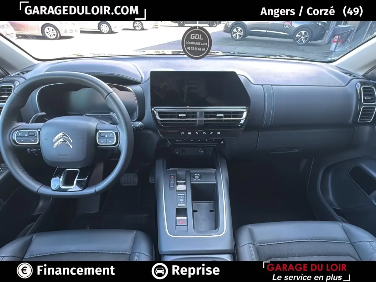 Intérieur noir du Citroën C5 Aircross 2025, vue frontale sur le tableau de bord et volant cuir multifonctions.