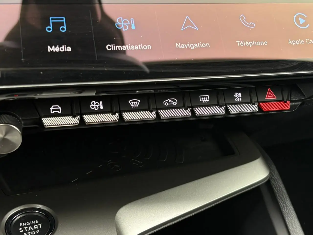 Gros plan sur la console centrale de la Peugeot 308 SW Hybrid 2025, avec écran tactile et boutons de commande lumineux.