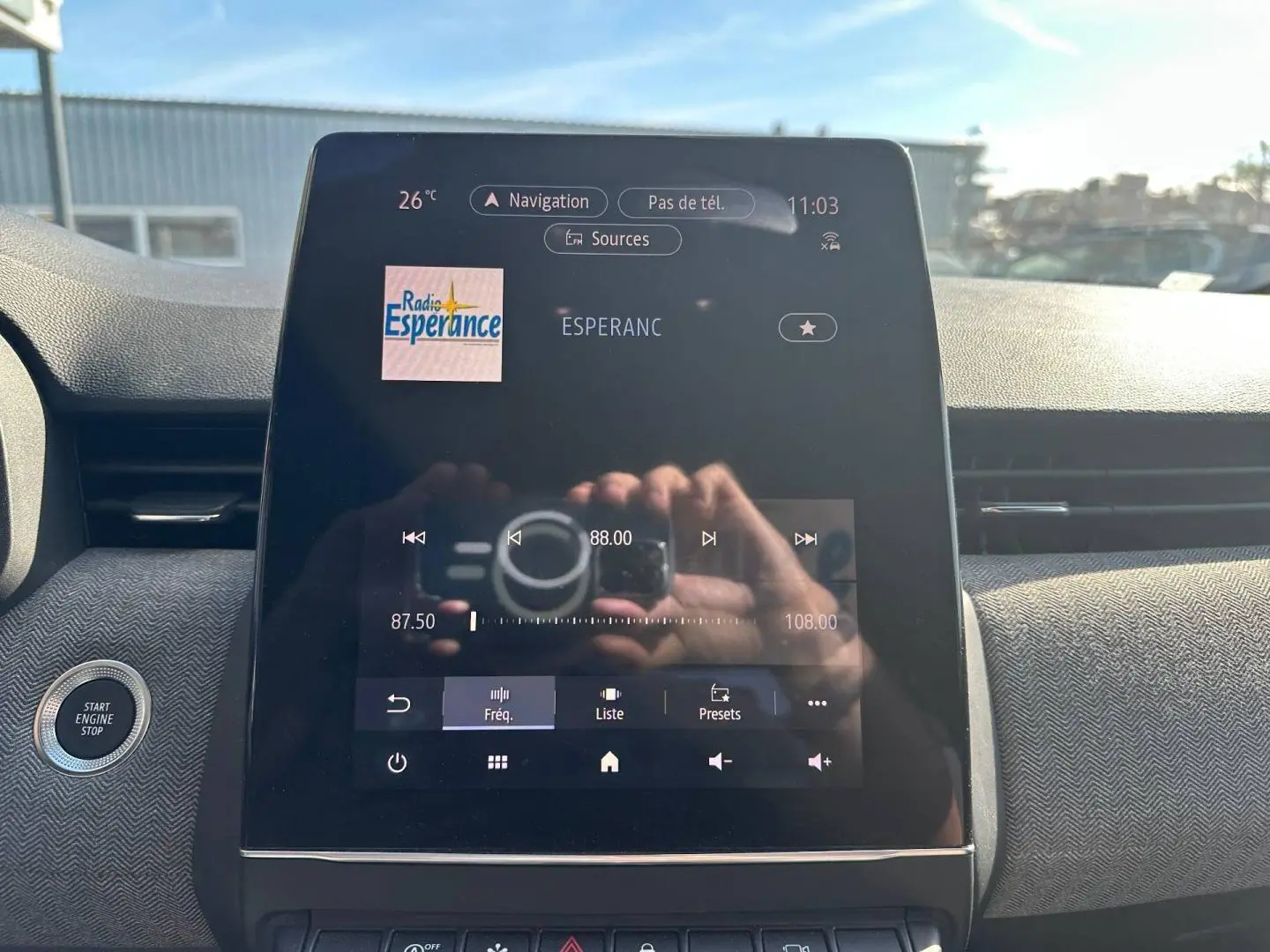 Écran tactile central de la Renault Clio 2025 affichant la radio, avec bouton Start/Stop visible à gauche.